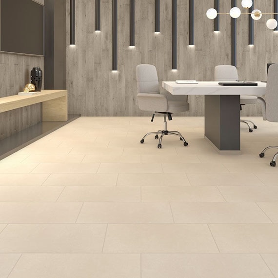 Conference room with beige floor tile, wall tile that looks like weathered wood, wall-mounted lighting, side table, white marble-top table and gray rolling chairs.