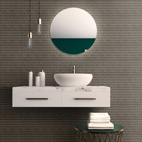 Floating bathroom vanity with white marble countertop, vessel sink, gray mini-picket mosaic tile backsplash, pendant lights, and round mirror.