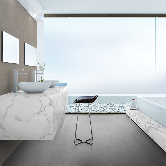 Bathroom with white & gray marble look porcelain slab bathtub surround and matching floating vanity with dual vessel sinks, and large walk-in shower with frosted glass.